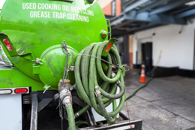 a technician pumping a grease trap in a commercial building in Moraine